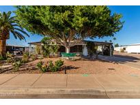 Charming single-story home with lush landscaping and a covered carport at 5502 E Baywood Ave, Mesa, AZ 85206