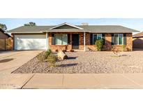 Charming single-story home with brick exterior, attached garage, and landscaped front yard at 1112 W Hackamore St, Mesa, AZ 85201