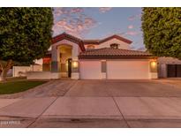 Inviting two-story home with a three-car garage and festive lighting at dusk at 2280 E Stephens Pl, Chandler, AZ 85225