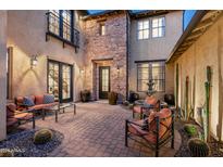 Inviting courtyard with a stone fountain, comfortable seating, and desert landscaping at 9424 E Hidden Spur Trl, Scottsdale, AZ 85255