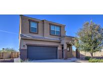 Two-story house with a large dark gray garage door and landscaping at 4689 E Argentite St, San Tan Valley, AZ 85143