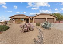 House exterior featuring desert landscaping and two-car garage at 250 Cottonwood Ln, Wickenburg, AZ 85390