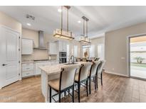 Modern kitchen with white cabinets, granite countertops, and an island at 21559 E Russet Rd, Queen Creek, AZ 85142