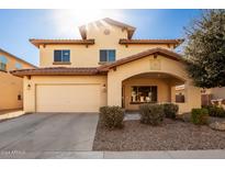 Two-story house with tan exterior, attached garage, and landscaped front yard at 45335 W Rhea Rd, Maricopa, AZ 85139