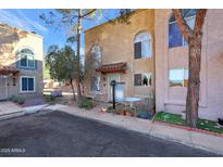 Tan two-story stucco building with arched windows, a small patio, and landscaping at 10015 N 14Th St # 7, Phoenix, AZ 85020