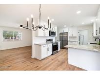 Remodeled kitchen with white cabinets, stainless steel appliances, and quartz countertops at 10404 W Audrey Dr, Sun City, AZ 85351