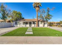Newly renovated home with artificial turf lawn and modern facade at 7538 E Garfield St, Scottsdale, AZ 85257