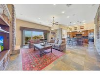 Spacious living area with stone fireplace and kitchen view at 10843 E La Junta Rd, Scottsdale, AZ 85255