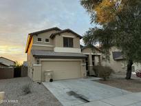 Two-story house with beige exterior, attached garage, and landscaping at 4112 S 249Th Dr, Buckeye, AZ 85326