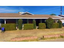 Brick ranch home with carport and well-manicured hedges at 3818 W Rose Ln, Phoenix, AZ 85019