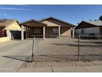 Tan house with covered porch and chain link fence at 6637 N 54Th Ave, Glendale, AZ 85301