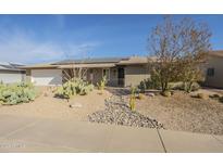 Single story home with desert landscaping, solar panels, and a two-car garage at 10108 W Oak Ridge Dr, Sun City, AZ 85351