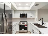 Modern kitchen with stainless steel appliances and white shaker cabinets at 1331 W Baseline Rd # 122, Mesa, AZ 85202