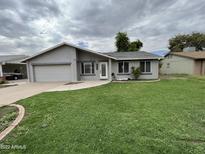 Single-story home with a green lawn and attached garage at 2455 E Holmes Ave, Mesa, AZ 85204