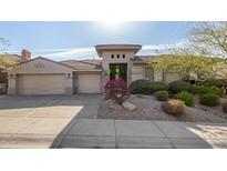 Beautiful desert landscape surrounds this single-story home with a three-car garage at 10975 E Greenway Rd, Scottsdale, AZ 85255