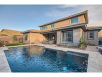 Inviting backyard oasis with a refreshing pool, spacious patio, and modern home at 4566 N Golf Dr, Buckeye, AZ 85396