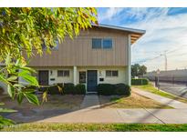 Tan two-story townhome with front yard landscaping and walkway at 2449 W Missouri Ave, Phoenix, AZ 85015