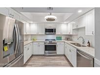 Modern white kitchen with stainless steel appliances and granite countertops at 4200 N Miller Rd # 309, Scottsdale, AZ 85251