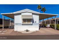 Inviting mobile home exterior with covered carport and landscaping at 205 S Higley Rd # 32, Mesa, AZ 85206