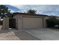 Tan colored garage with driveway and landscaping at 5839 E Norwood St, Mesa, AZ 85215