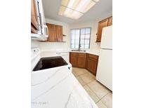 Bright kitchen with wood cabinets, white countertops, and tile flooring at 930 N Mesa Dr # 2034, Mesa, AZ 85201