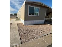 Tan mobile home exterior with carport and gravel landscaping at 9431 E Coralbell Ave # 61, Mesa, AZ 85208