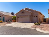 Tan house with two-car garage and desert landscaping at 11553 W Sonoran Ct, Surprise, AZ 85378