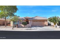 Single-story home with tile roof, two-car garage, and desert landscaping at 143 S Hancock Trl, Casa Grande, AZ 85194