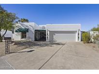 Single-story home with a white stucco exterior, attached garage, and landscaped front yard at 506 E Tam Oshanter Dr, Phoenix, AZ 85022