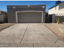 Attached garage with a large driveway and desert landscaping at 619 E Jensen St # 55, Mesa, AZ 85203