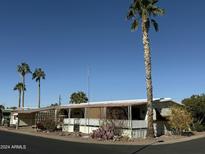 Single-wide manufactured home with covered porch and desert landscaping at 9501 E Broadway Rd # 269, Mesa, AZ 85208