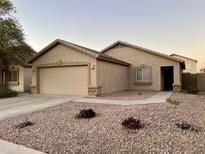 Single-story house with a two-car garage and desert landscaping at 11612 W Lee Ln, Youngtown, AZ 85363