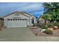 Single-story home with a two-car garage and landscaped front yard at 18048 W Spencer Dr, Surprise, AZ 85374