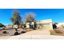 Light green house with a two-car garage and a landscaped front yard at 1750 E Camino Ct, Chandler, AZ 85225