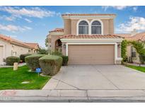 Two-story house with tan exterior, arched windows, and a two-car garage at 1321 W Clear Spring Dr, Gilbert, AZ 85233