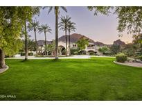 Elegant estate home with lush landscaping, a long driveway, and mountain views at 6161 N 59Th Pl, Paradise Valley, AZ 85253