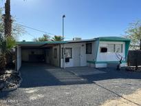 Single-wide mobile home with carport and gravel driveway at 9623 E Baywood Ave, Mesa, AZ 85208