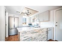 Modern kitchen with gray cabinets, stone backsplash and island at 2020 W Union Hills Dr # 246, Phoenix, AZ 85027