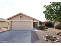 Tan house with a two-car garage and well-maintained landscaping at 15721 W Lundberg St, Surprise, AZ 85374