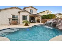 Inviting backyard pool with a waterfall feature and patio at 18407 W Fulton St, Goodyear, AZ 85338