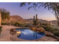 Inviting pool with mountain views and a serene waterfall feature at 10040 E Happy Valley Rd # 2046, Scottsdale, AZ 85255