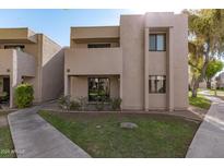 Tan two-story condo building with walkway and landscaping at 1920 W Lindner Ave # 147, Mesa, AZ 85202