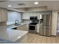 Modern kitchen with stainless steel appliances and white cabinets at 3946 W Cholla St, Phoenix, AZ 85029