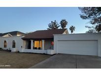 White single story home with a red tile roof, two-car garage, and landscaping at 1745 E Glade Ave, Mesa, AZ 85204