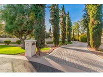 Long paved driveway with mature trees leading to a luxurious home at 7133 E Berneil Dr, Paradise Valley, AZ 85253