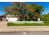 Ranch style home with white picket fence and mature landscaping at 608 W Los Lagos Vista Ave, Mesa, AZ 85210