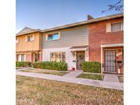 Brick and gray exterior of a charming townhome with well-manicured landscaping at 8405 E Montebello Ave, Scottsdale, AZ 85250