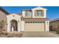 Two-story house with tan siding, brown roof, and a two-car garage at 17622 W Missouri Ave, Litchfield Park, AZ 85340