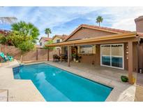 Inviting backyard oasis featuring a refreshing pool, covered patio, and dining area at 4636 E Danbury Rd, Phoenix, AZ 85032