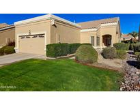 Tan stucco house with a two-car garage and well-manicured lawn at 8428 W Utopia Rd, Peoria, AZ 85382